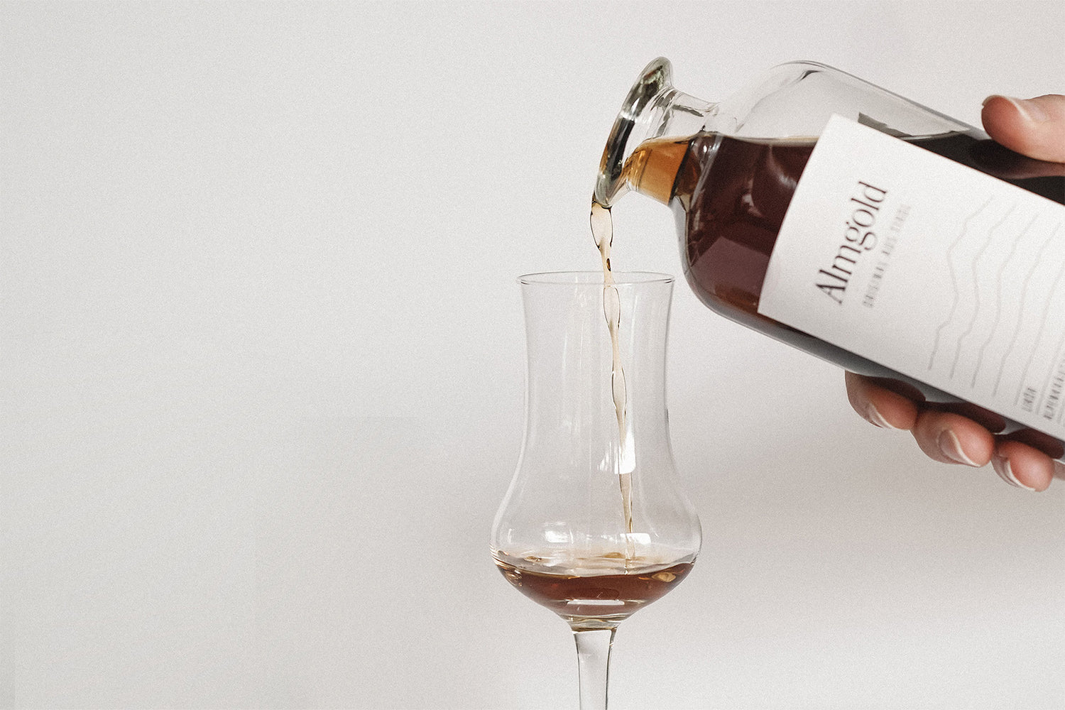 Almgold wird eingeschenkt in ein Grappa Glas